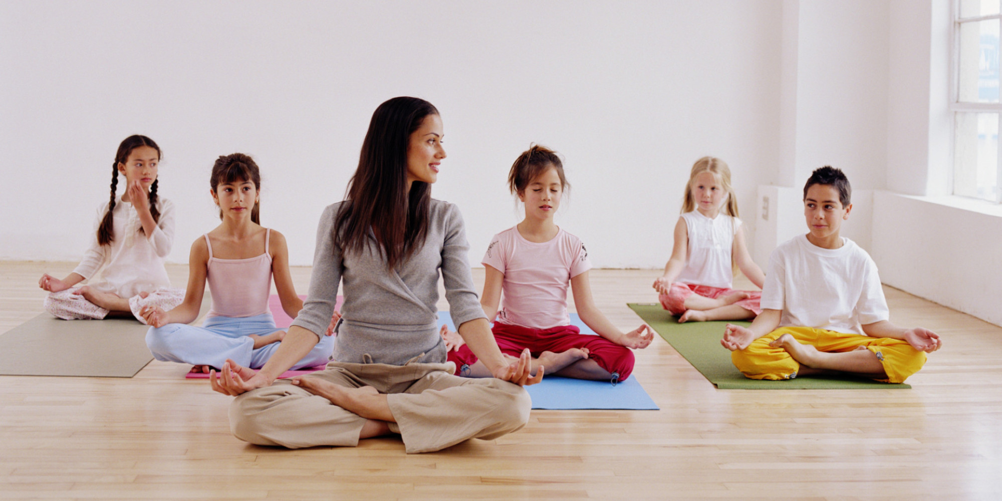 Woman teaching children (7-10) yoga